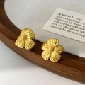 Dettaglio ravvicinato di orecchini a fiore in oro opaco con eleganti petali testurizzati - Orecchini a lobo a fiore / Oro
