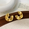 Detail van gouden waaiervormige geplooide oorbellen met kristallen op houten voet - Goud