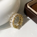 Nahaufnahme des vergoldeten Rings mit Zirkoniasteinen in Krappenfassung - Goldfarbener quadratischer Zirkonring