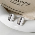 Macro shot of silver polished rectangular stud earrings on a minimalist background - Silver