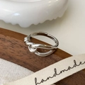 Macro detail of silver knot ring with handmade ribbon on a dark wooden surface - Knot Style / Silver