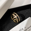 Detaillierte Makroansicht eines goldenen Doppelringes mit Mikro-Diamanten auf schwarzem Samt - Goldener doppelschichtiger Sternring