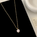 Detail der Halskette mit Zirkonia-Anhänger und Goldkette auf schwarzem Samt - Gold