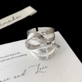 Detail of silver bow ring with layered textures and brushed metal finish design - Silver