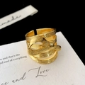 Detail view of gold multi-layer bow ring showing textured metal and open band design - Gold