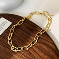 Detalle de un collar de cadena con eslabones dorados pulidos en una bandeja de madera zen - Collar de Cadena Gruesa (Chapado en Oro Real)