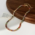 Dettaglio della collana con zirconi arcobaleno, catena dorata e chiusura a moschettone - Collana Multicolore