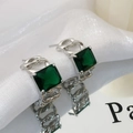 Detail of vintage square emerald zircon earrings with silver chain border on silk - Silver Green Zirconia