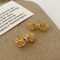 Macro detail of gold bow-knot earrings with lace texture and heart zircon stone - Golden Lace Woven Bow (A-1646)