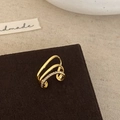 Detalle macro de un earcuff dorado de tres capas con pavé de circonitas brillantes - Pendiente de Cartílago Dorado de Triple Capa con Circonita / Dorado