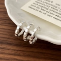 Detailed view of triple-layer silver block ear cuffs on a white ceramic plate - Silver