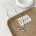 Detail of blue fish tail pendant necklace with silver beads and grey pearls on a tray - Grey High Bright Pearl Blue Whale Tail Necklace