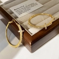 Detailaufnahme goldener Creolen mit funkelnden Zirkonia-Kreuzanhängern und Metallglanz - 4cm / Gold