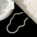 Detail van een elegante gouden ketting met rechthoekige zirkonen en verstelbare ketting - Volledige Zirkonia Verstelbare Schuifketting