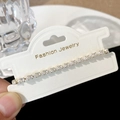 Close-up of sparkling cubic zirconia adjustable bracelet on a fashion jewelry card - Rhinestone Pull String Bracelet / Gold