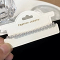 Close-up of sparkling oval zircon bracelet on fashion jewelry card in silver finish - Rhinestone Pull String Bracelet / Silver