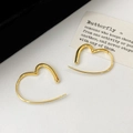 Macro shot of minimalist gold heart-shaped hoop earrings on a textured background - Gold Heart Stud Earrings / Gold