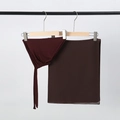 Detail view of burgundy chiffon hijab and matching inner cap hanging on a clothes rack - Coffee