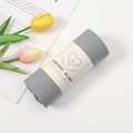 Grey crinkled cotton blend scarf rolled with a branded paper sleeve on white background - Light Grey / 180-90cm
