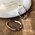 Macro detail of irregular layered silver hoop earrings on ceramic and rustic burlap backdrop - Silver Double Layer Hoop