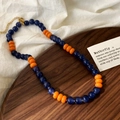 Dettaglio della collana di perline di vetro blu e arancioni con chiusura a moschettone - Arancione / Blu Scuro