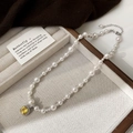 Détail du collier de perles avec un pendentif en pierre jaune carrée et extension argentée - Collier Perle Blanche Zircon Jaune