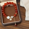 Dettaglio del bracciale di agata rossa con fiore di camelia e ciondolo a stella d'oro - Bracciale con perline di agata rossa