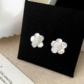Nahaufnahme eleganter Blumenohrringe mit weißen Muschelblättern und Zirkonia-Steinen - Silberne Blumenohrstecker / Silber