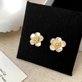 Detailansicht eleganter goldener Blumenohrringe mit weißen Muschelblättern und Zirkon - Goldene Blumenstecker / Gold