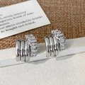 Dettaglio di orecchini a C multistrato argentati con zirconi con taglio a baguette - Stile Intrecciato Zirconia Argento