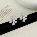 Dettaglio macro di orecchini a fiore in argento con zirconi e una perla centrale - Orecchini a lobo a fiore d'argento