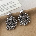 Macro detail of silver cluster bead earrings with polished metal spheres on a textured base - Silver Tassel Earrings