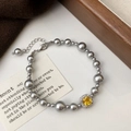 Detail of grey pearl bracelet featuring a square yellow zircon center stone and lobster clasp - Gray Pearl Yellow Zircon Bracelet