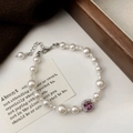 Détail macro d'un bracelet de perles avec pierre carrée violette et fermoir mousqueton - Bracelet Perle Blanche Zircon Violet
