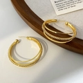 Primer plano de los pendientes de aro dorados multicapa con circonitas y acabado brillante - Pendientes de oro