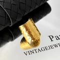 Makro-Detail des vergoldeten breiten Rings mit handgefertigter Hammerschlag-Textur - Gold