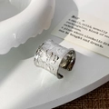 Macro shot of silver wide open ring with irregular lava texture on white podium - Silver