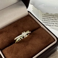 Close-up of golden criss-cross ring with pavé zircons in a brown velvet jewelry box - C-116 Cross Star Style (C-116) / Green