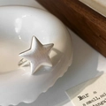 Primer plano de anillo de estrella en plata mate con textura de metal cepillado - Plateado