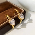 Dettaglio degli orecchini con zirconi a forma di cuore placcati oro su scatola in velluto - Oro