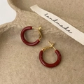 Dettaglio ravvicinato di orecchini a cerchio a C rosso scuro con perni dorati su vassoio - Rosso Ancor (2cm)
