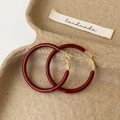 Detail van bordeauxrode emaille oorringen met gouden haken op een natuurlijk dienblad - 4cm Ankara Rood Ring