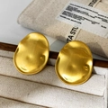 Detail van onregelmatige ovale gouden oorknopjes met een verfijnde geborstelde textuur - Goud