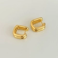 Detailed close-up of double-layered square gold hoop earrings on reflective surface - Gold