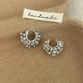 Macro detail of silver pearl hoop earrings with clustered crystals on a rustic base - Silver