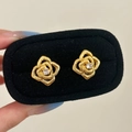 Detail von goldenen Rosenohrringen mit Zirkonia-Zentrum in einer schwarzen Schachtel - Rosenform / Gold