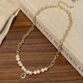 Détail d'un collier doré élégant avec perles et pendentif en pierre verte en goutte - Goutte d'Eau Verte