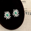 Detailed macro shot of irregular fireworks stud earrings with emerald green gemstones - Silver Green Zircon