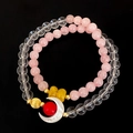Detailed macro of a double-layer crystal bracelet featuring a white crescent moon charm - Pink Crystal