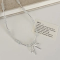 Detail of beaded cat's eye stone necklace with silver metal bow pendant and tubing - White Cat's Eye Stone Bowknot Necklace